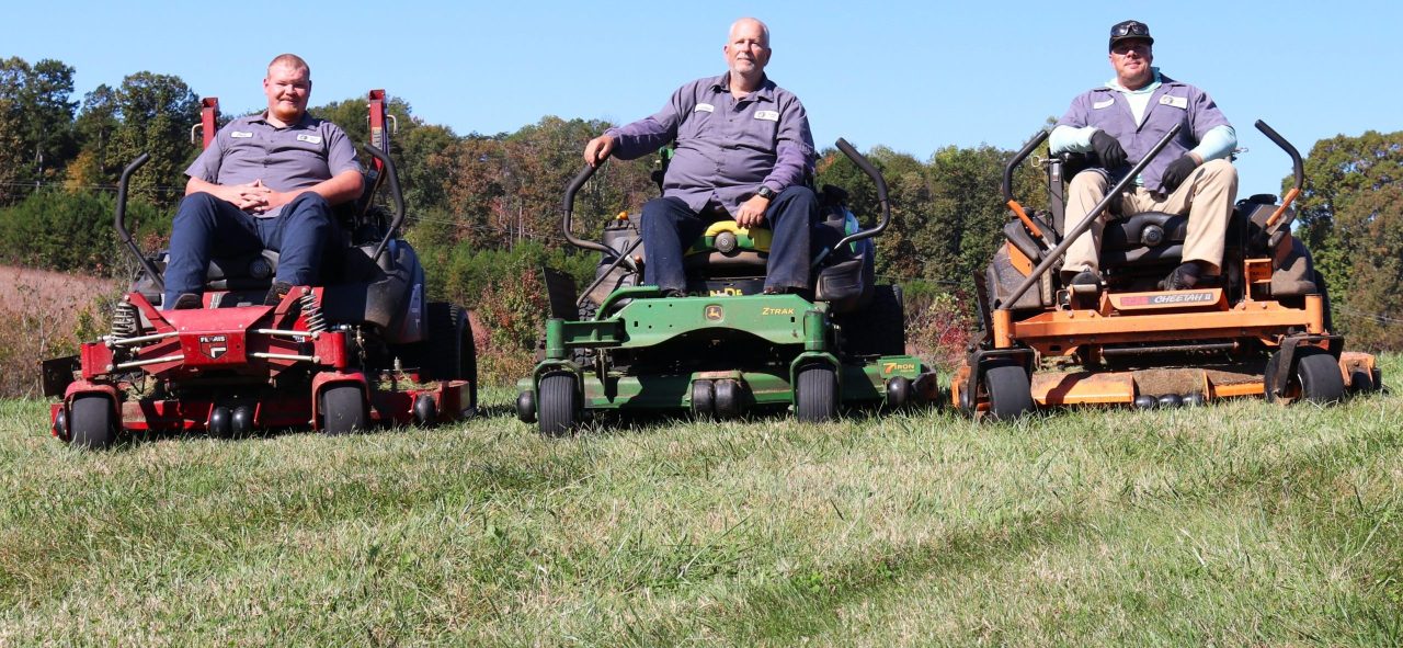 Jack Bumgarner, Frankie Hass, and Jeremy Hefner pose for a photo on their mowers at the CVCC Alexander Complex.