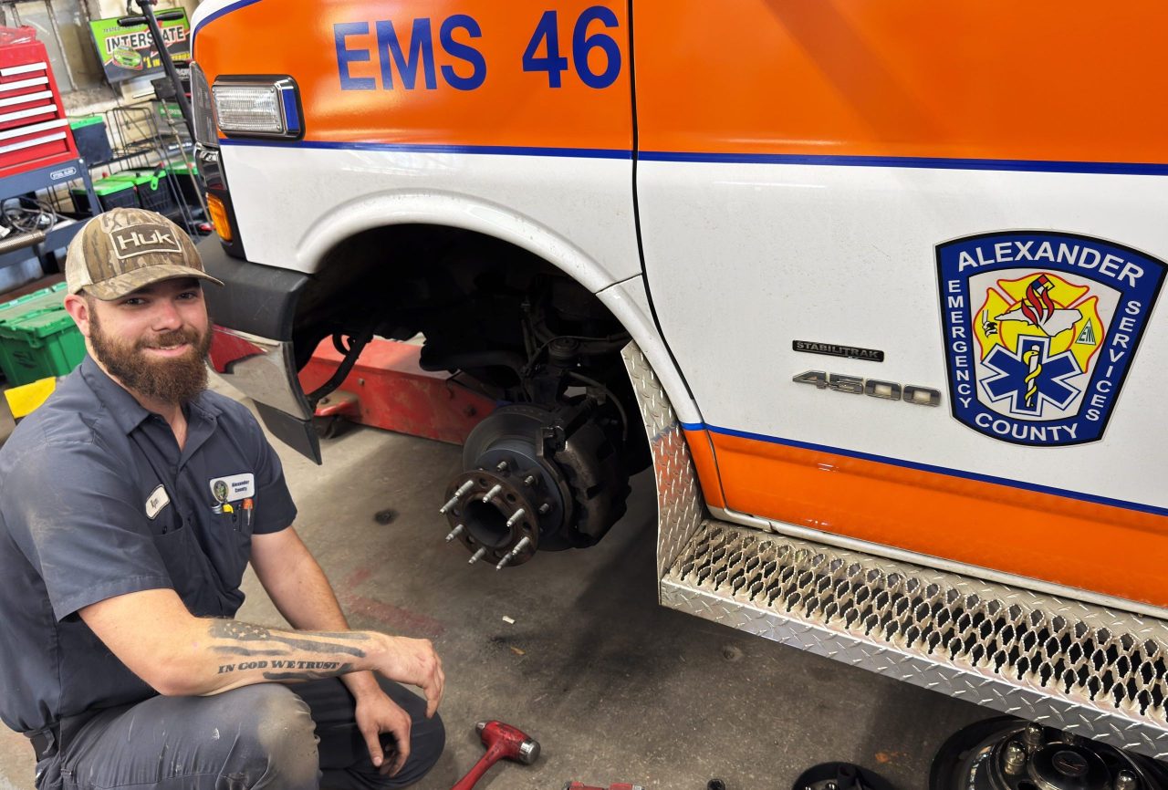Ryan Hudler is working on the front left brakes of an ambulance.