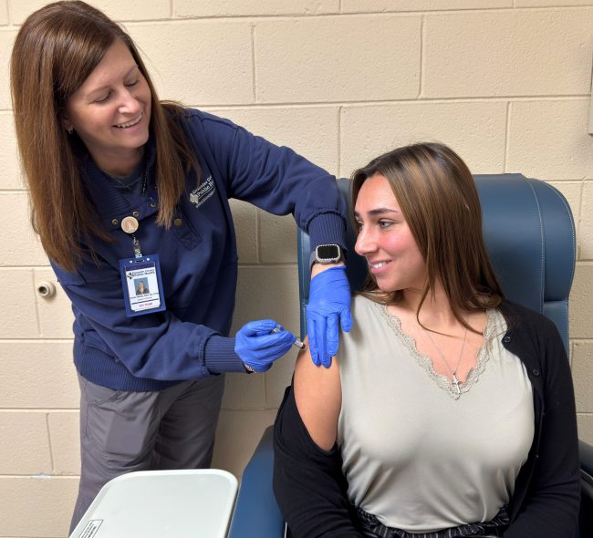 Kaitlyn Graves, Health Educator (right), receives a flu shot from Dori Maltba, Public Health Nurse Director.