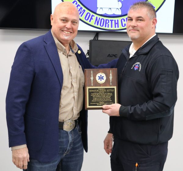 EMS Director Jeff Sigmon presents a plaque of appreciation to NC Senator Eddie Settle, who was instrumental in securing state funding for the EMS expansion.