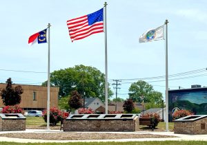 Three flags flying over the Charters of Freedom