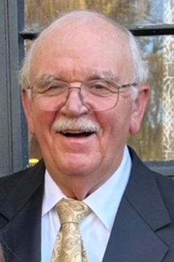 Dr. Warren Hollar wearing a coat and tie